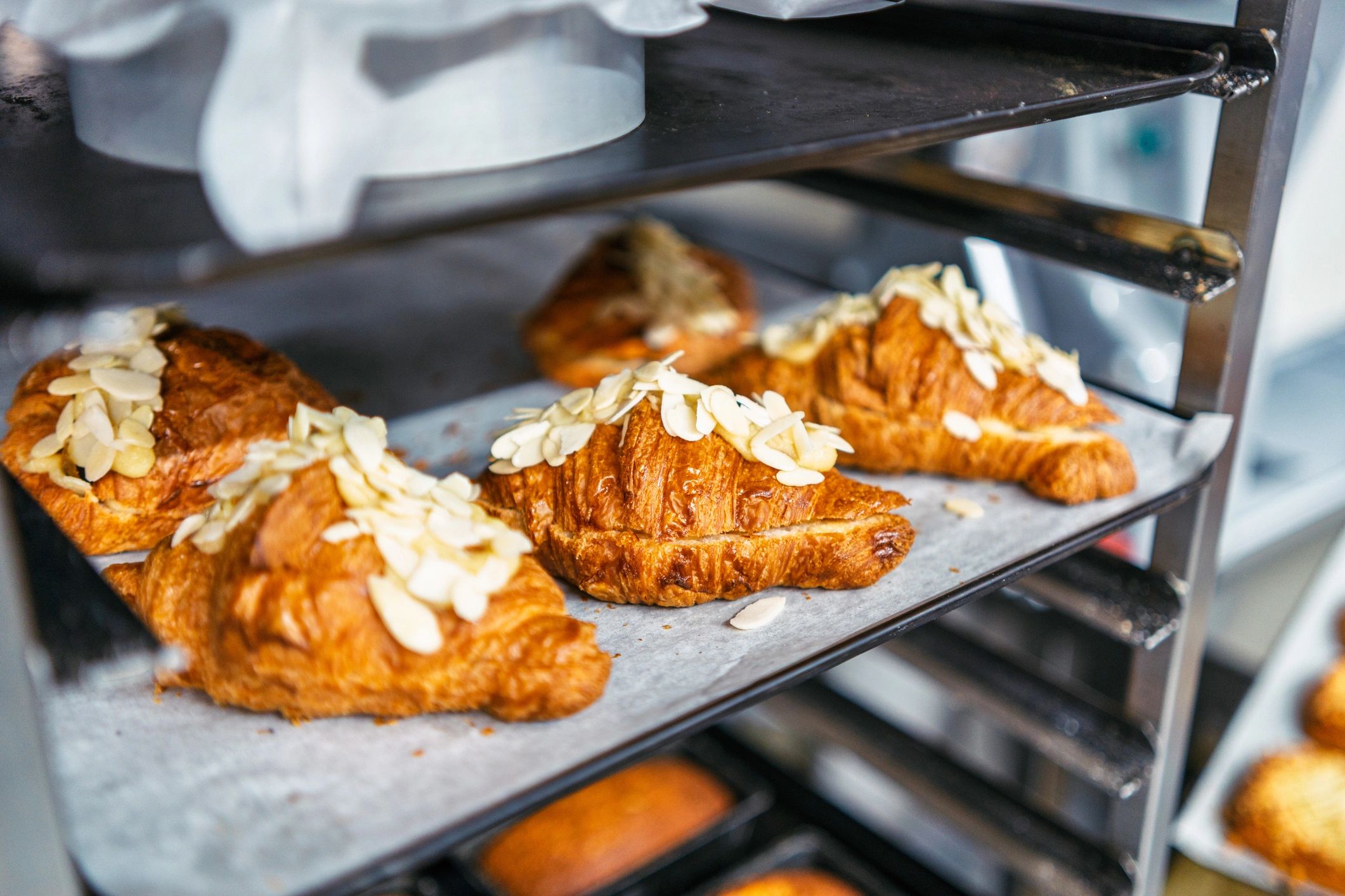 Golden-brown croissants cooling on a rack