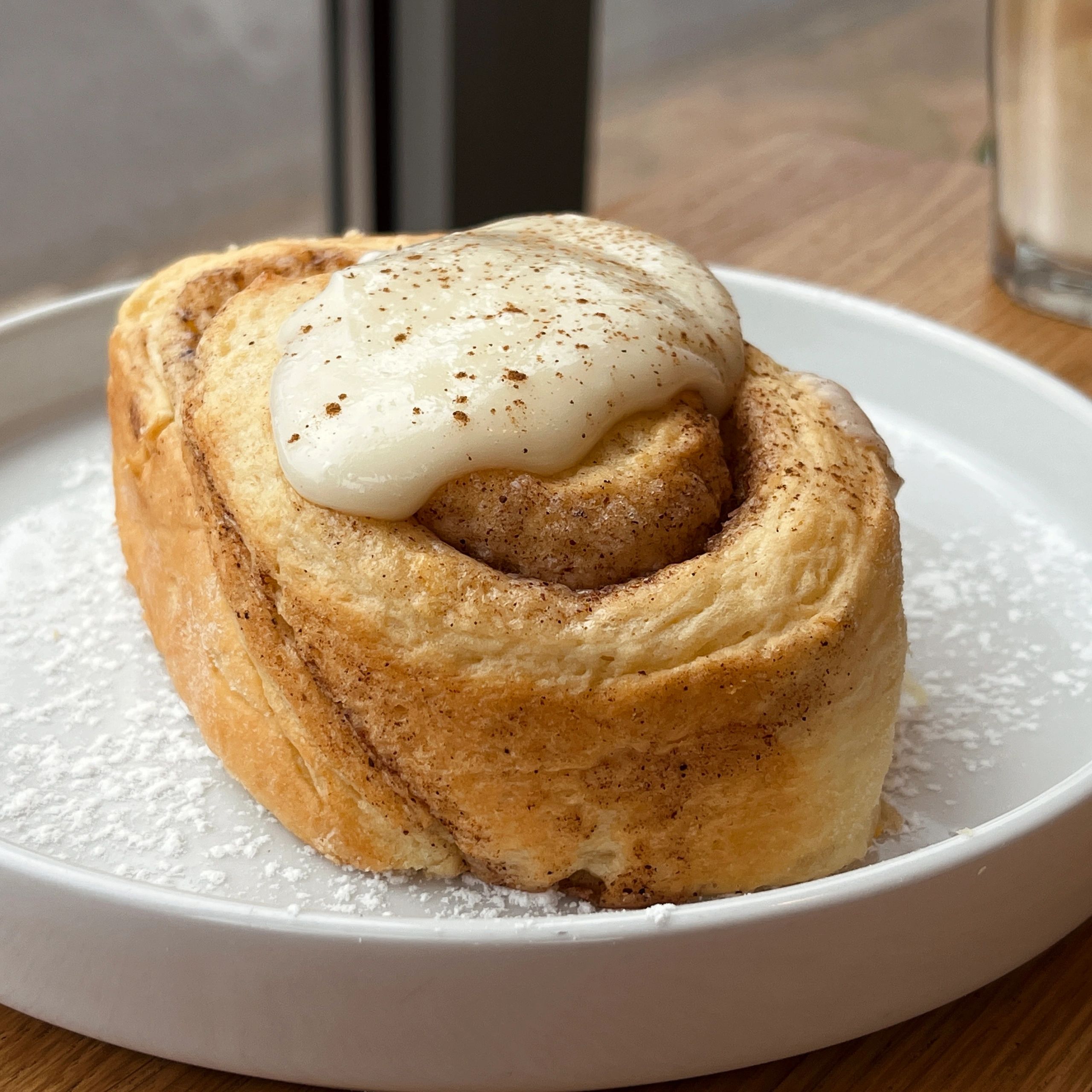 Cinnamon roll with creamy icing on a plate
