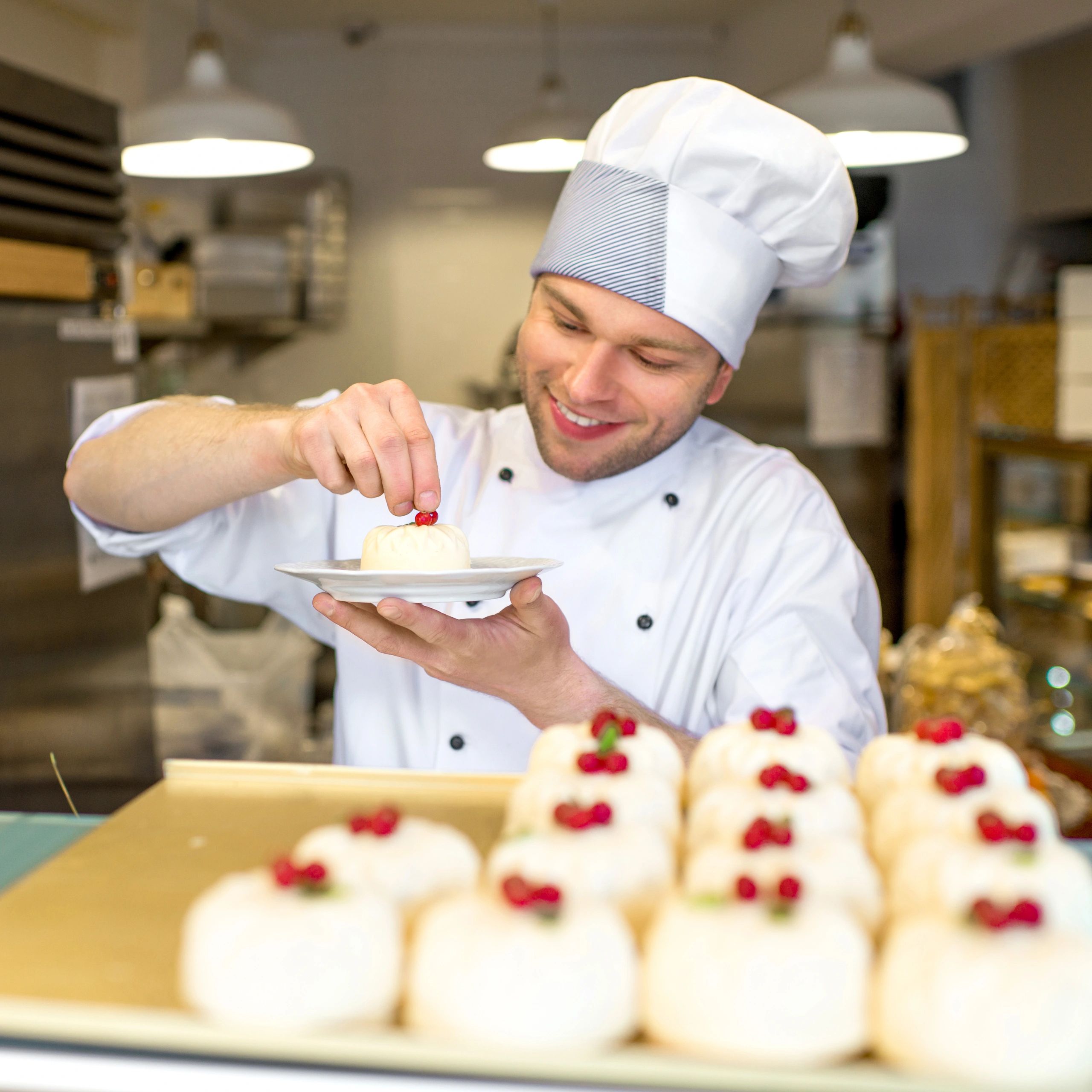 Pastry chef decorating desserts in a bakery