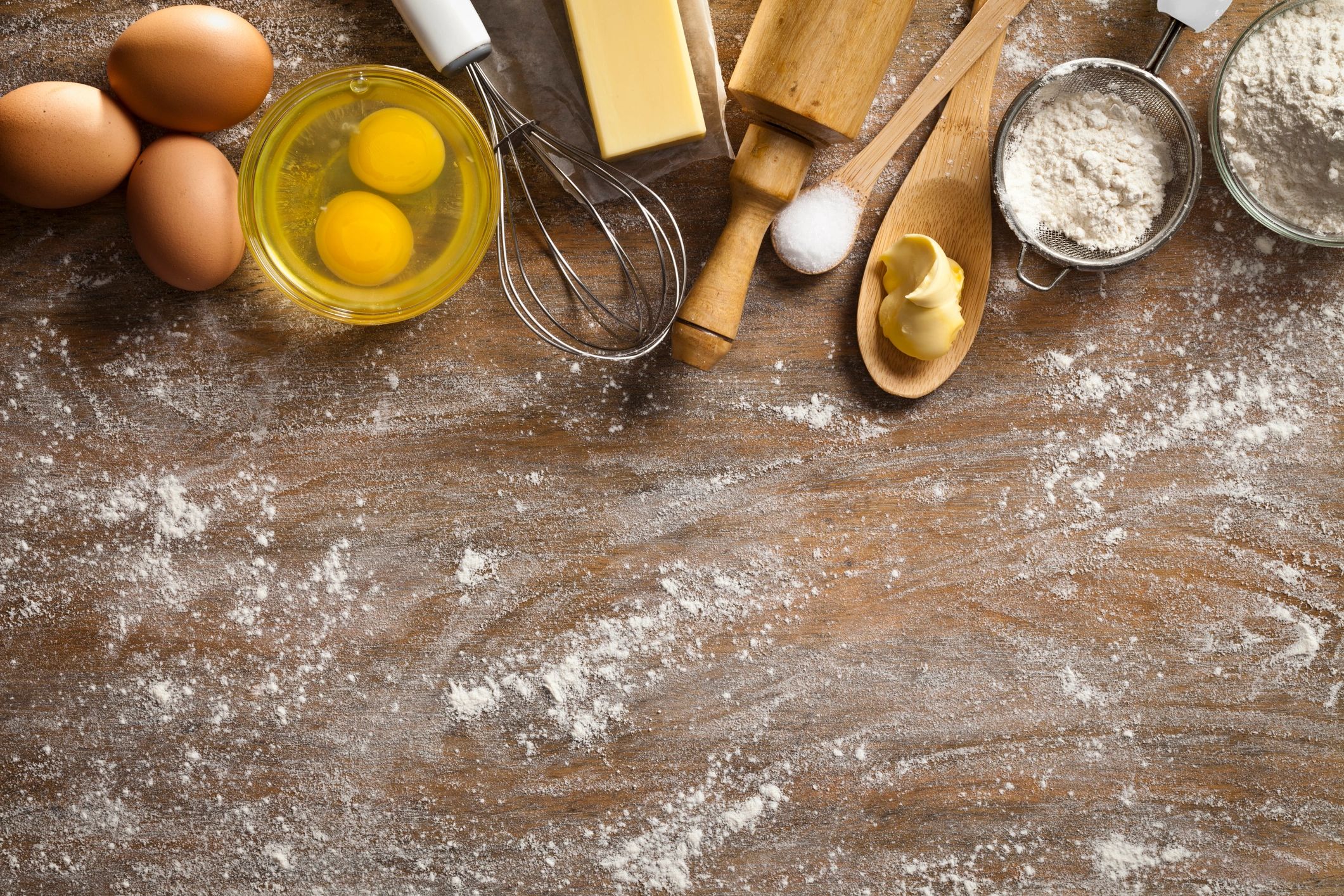 Baking ingredients and utensils on a rustic wooden table with copy space